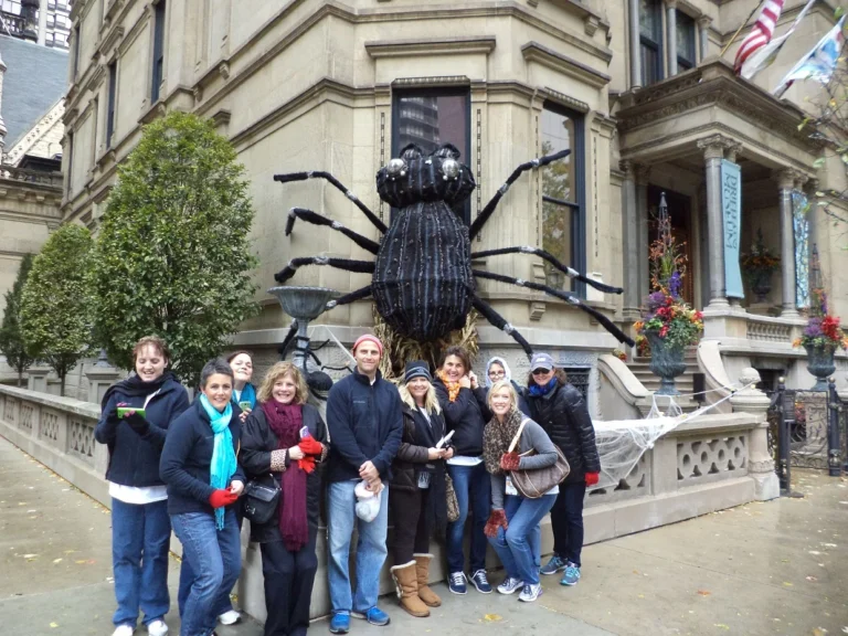 Group posing by a giant spider decoration at a destination on our corporate scavenger hunt